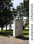 Small photo of Knoxville, Arkansas USA - August 30th, 2022: A white Murdock porta potty stands on the outskirts of Cabin Creek Park and Public Use Area in Knoxville, Johnson County, Arkansas, USA.