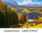 Autumn scenery of Dolomite Alps. Colorful hills and rocky mountains under picturesque sky. Alpine village Santa Cristina Val Gardena. It is a famous resort in the Dolomites, Italy