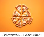 Cheese pizza cut in equal pieces on an orange seamless background. Flat lay of four cheese pizza. Quattro formaggi Italian pizza.
