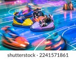 Young people are driving bumper cars in a amusement park.