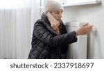 Small photo of Young woman feeling cold at home calling repairman to fix broken heating radiator. Concept of energy crisis, high bills, broken heating system, economy and saving money on monthly utility payments.