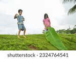 Small photo of 15 November 2012, Jawa Tengah Indonesia, anak-anak bersenang-senang bermain di alam. Salah satu anak memegang daun pisang