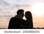 Silhouette photo of a couple in love at sunset.Portrait of a man and a woman.Photo at sunset.Silhouette portrait.Rays of the sun.Romantic photo.Backlight.Hugs of a couple in love.Sensual photo.Date.
