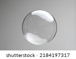 Flying soap bubbles on grey background. Abstract soap bubbles with reflections. Soap bubbles in motion background.