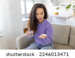 Small photo of Asian woman takes pill with glass of water in hand. Stressed female drinking sedated antidepressant meds. Woman feels depressed, taking drugs. Medicines at work