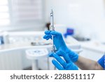 Small photo of Close up of anesthesia syringe in the hands of a dentist doctor. Anesthetist dentist doctor holds in his hand anesthesia syringe prior to dental surgery. Hand in a rubber glove