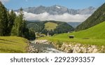 Small photo of Summer view on the charming Austrian village Umhausen with the rive otz in the foreground and surrounding mountains in the background. Tirol, Austria. summer, vacations, idyllic.
