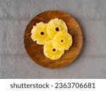 Small photo of Dry Pineapple Rings on Wood Plate, Candy Pineapples, Dehydrated Yellow Sugar Fruit, Candied Fruits Circles, Dry Pineapple on Rustic Background