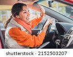 Small photo of Polite woman driver raised her hand as a sign of respect and says thank you for giving way. Relations between people in traffic regulations