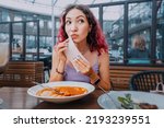 Small photo of The girl observes tact and good manners and wipes her mouth after a hearty meal in a cafe. First Date and Eating Behavior