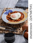 Small photo of Pisto Manchego (Manchego ratatouille) with fried egg ingredients, red and green peppers, onion, courgette and eggs. Concept typical and traditional food of Spain. Vertical photo and selective focus.