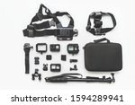 Flat lay of action camera with accessories on white background top view.