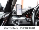 Smartphone with navigation route on screen mounted on phone holder at car dashboard