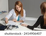 A doctor consulting oxygen saturation and heart rate with a pulse oximeter.Mature female professional doctor with stethoscope on shoulders measuring oxygen saturation of young woman.