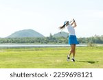 Small photo of Golfer sport course golf ball fairway. People lifestyle woman playing game golf and hitting go on green grass river and mountain background.  Asia female player game shot in summer