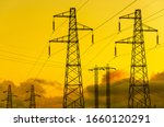 Energy  Transmission towers or electricity pylons with golden sky and clouds