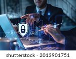 Small photo of Two colleagues working together to protect clients confidential information and cyber security. IT hologram padlock icons modern office background at night time