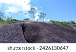 Small photo of Natural View Of Mountain Rocks With Blackish Colors On The Tropical Hills Of Daya Baru Village, Indonesia