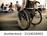 Small photo of Rear view of businesswoman with disability uses wheelchair while going through the office.