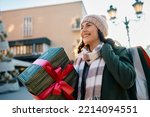 Happy woman enjoying in Christmas shopping during winter day in the city. 