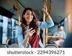 Happy woman text messaging on mobile phone while riding in a bus. 