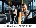 Small photo of Young happy man using mobile phone while riding in city bus.