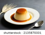 Cream caramel pudding with caramel sauce in plate on rustic table