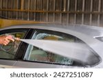 Small photo of A gleaming car gleams under a cascade of thick foam and high-powered water at a modern car wash station