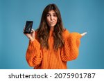 Long haired upset woman holding a out-of-use smartphone with broken screen and throw up hands in disbelief 