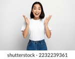 Happy surprised woman looking at camera with mouth open in amazement, expressing shock, astonishment. indoor studio shot, white background 
