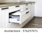 Opened kitchen drawer with plates inside, a smart solution for kitchen storage and organizing. 