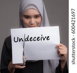 Small photo of A pretty girl cut the word undeceive. Transformation from negative to positive or bad to good concept.