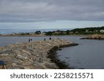 Small photo of Bearskin Neck in Rockport, MA on a partly cloudy summer afternoon. View of water and nature outside of Boston.