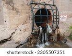 Small photo of Denver, Colorado, United States - 5.11.2023: heavy rainfall consequences on Cherry Creek trail, one of Denver's most popular trails flooded. A culvert with trash hanging off metal grid