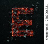 Small photo of A photo of a burning capital letter E on a black background is made of hot coals.