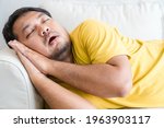 Small photo of Asian man take a nap on sofa with snore.take nap daydreaming in living rooms snoring.Healthcare medical.Sleep health.man sleep at home.Dream, rest, tired father dad day.Sleep Apnea.Sdb.resting at home