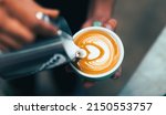 Small photo of Cappuccino or latte with frothy foam, blue coffee cup top view closeup on barista hand background.Cafe and bar, barista making latte art.fresh cappuccino coffee mug in cafe.caffeine roasted arabica.