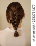 Small photo of Young woman with mid-length dark blonde hair styled in a French plait. French braid. Casual hairstyle. Elegant hairstyle.