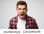 Small photo of Furious,enraged man with grumpy grimace on his face,with mouth opened in shout, ready to argue and swear, wants to gain respect, show strength, isolated over white background