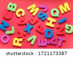 Bright multicolored alphabet background. Multicolored letters on red background. Flat Lay, top view