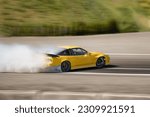 Small photo of Car drifting. Blurred of image diffusion race drift car with lots of smoke from burning tires on speed track. Sport concept. Yellow Japanese sport car