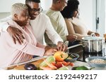 Happy black family cooking inside kitchen at home - Soft focus on mother face