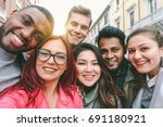 Happy friends from diverse cultures and races taking selfie with back lighting - Youth and friendship concept with young people having fun together - Main focus on left two guys - Retro filter