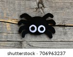 Creating a felt Halloween spider ornament. Step. Cute Halloween spider ornament isolated on a vintage wooden background. Things to make with felt sheets. Top view. Closeup