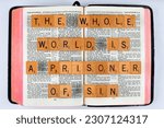 Small photo of Vancouver, BC, Canada - Circa May 2023: Scrabble letters spelling Bible Verse Galatians 3:22 The whole world is a prisoner of sin