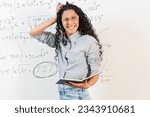 Small photo of Portrait of Middle Eastern female student stressed and chagrin. Woman holding her head, face expresses anxiety and misunderstanding. background is a blackboard with mathematical equations.
