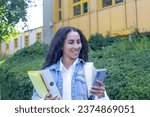 Small photo of Happy confident Eastern woman look at the screen phone typing message holding folders with documents found the application online. Student on the brack or girl in a job center getting new work.