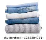 Stack of clothing jeans sweaters on a white background isolation
