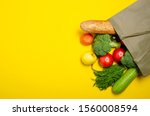 Food vegetable, bread, fruit in eco grocery bag on yellow background, top view