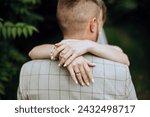 Small photo of Brides hand arm around groom. Wedding day moment. Bride holding grooms shoulder, in love couple on wedding day together. Bride and groom. flowers and rings. Brides hand holding groom.